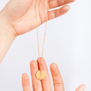 Necklace held up to show the chain length and pendant size